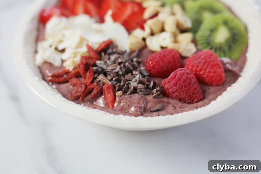 Superfood berry smoothie bowl topped with berries, cacao nibs, nuts and coconut