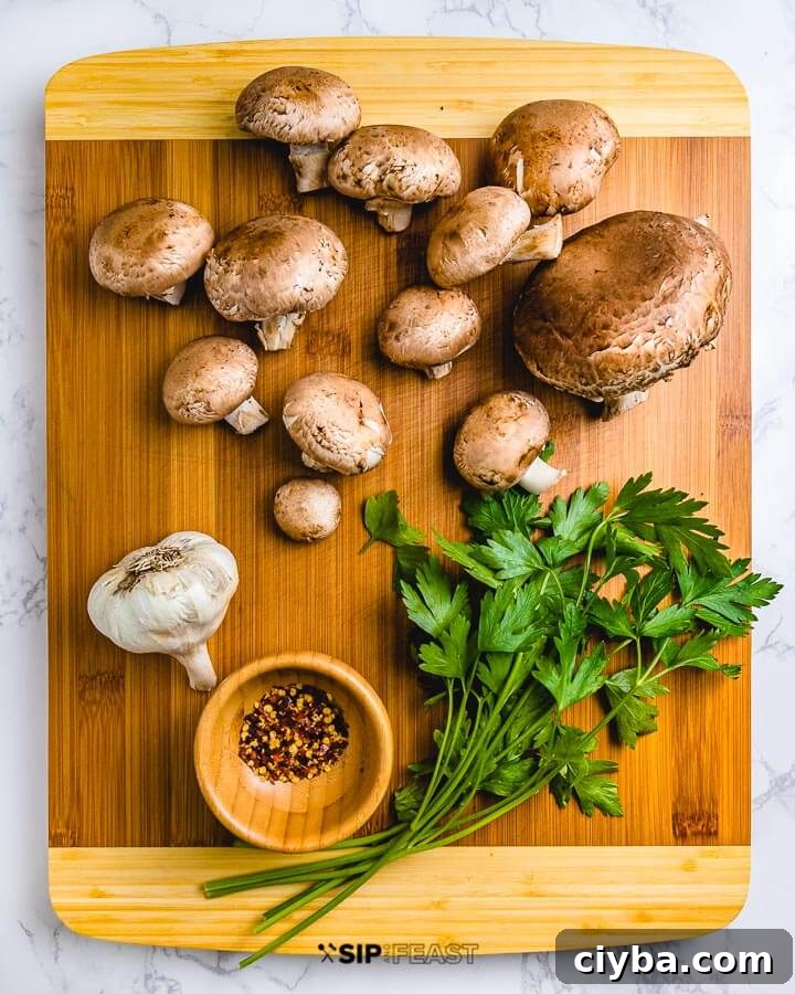 Cutting board with baby portobello mushrooms, garlic, chili flakes, and fresh parsley.