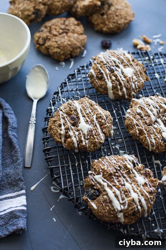 Morning Glory Breakfast Cookies arranged on a wire rack topped with white chocolate drizzle.