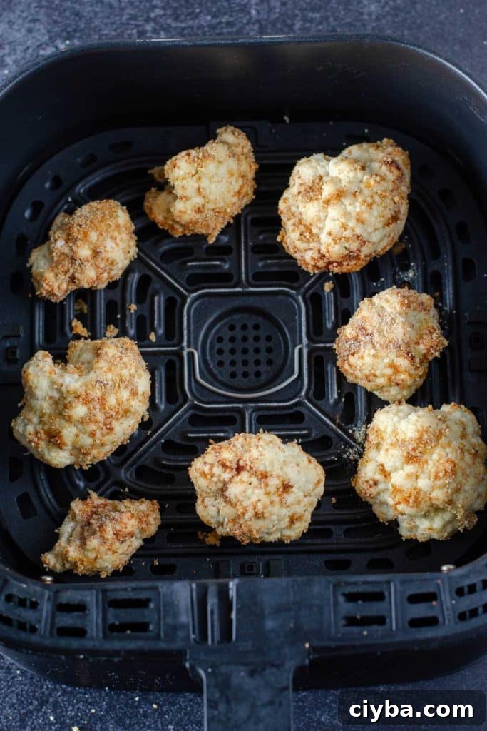 Breaded cauliflower florets in an air fryer basket