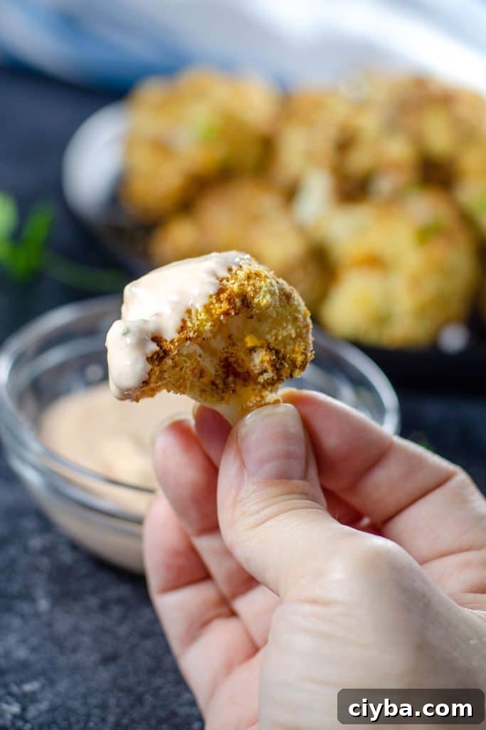 Cauliflower Bites dipped in buffalo dipping sauce 