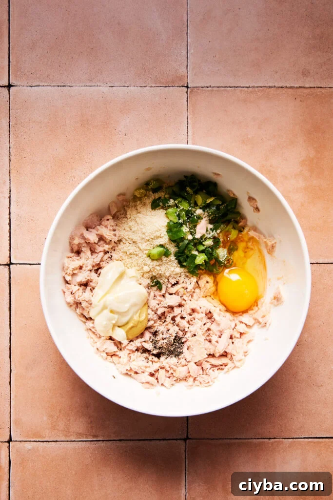Tuna mixture in a white bowl ready to be shaped into patties