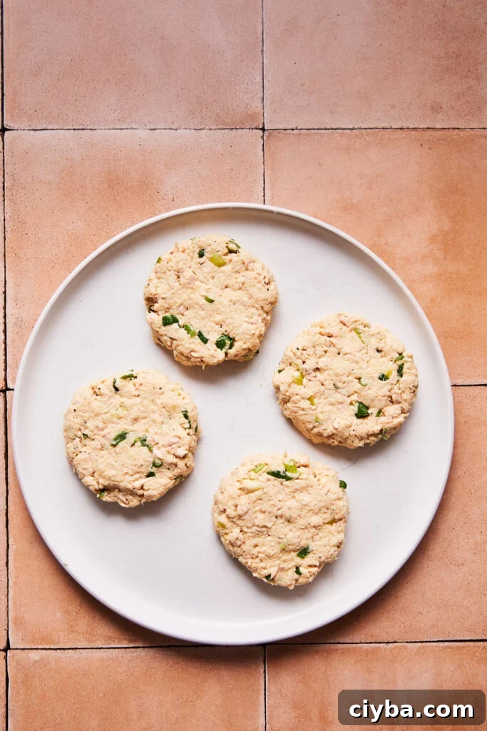 Formed tuna patties on a cutting board before cooking