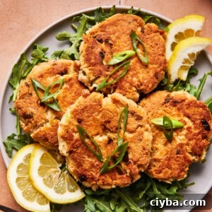 Four crispy tuna patties on a blue plate with herbs