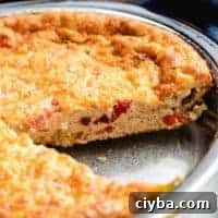 A slice of the quiche has been removed from the pie.