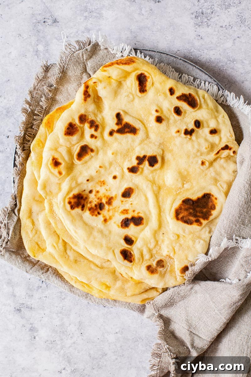 Quick Homemade Flatbread Recipe with Video Tutorial 5 pita breads stacked wrapped into grey cloth napkin