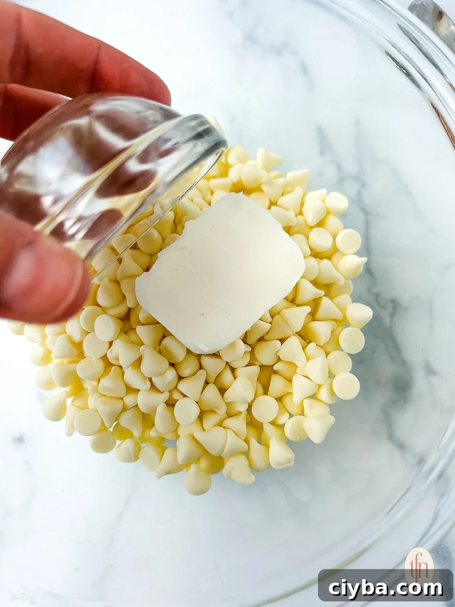 Adding Crisco shortening to white chocolate chips in a large glass bowl.