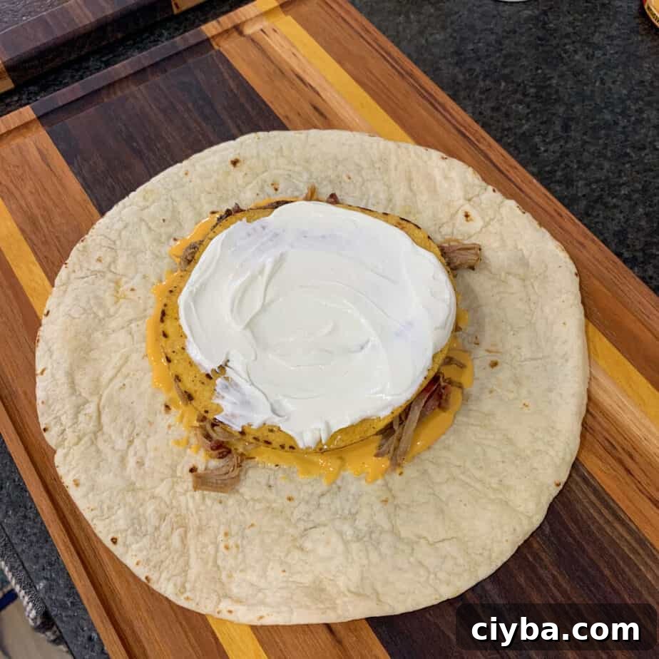 Crispy Pulled Pork Crunchwrap Supreme Recipe 7 tostada shell topped with sour cream