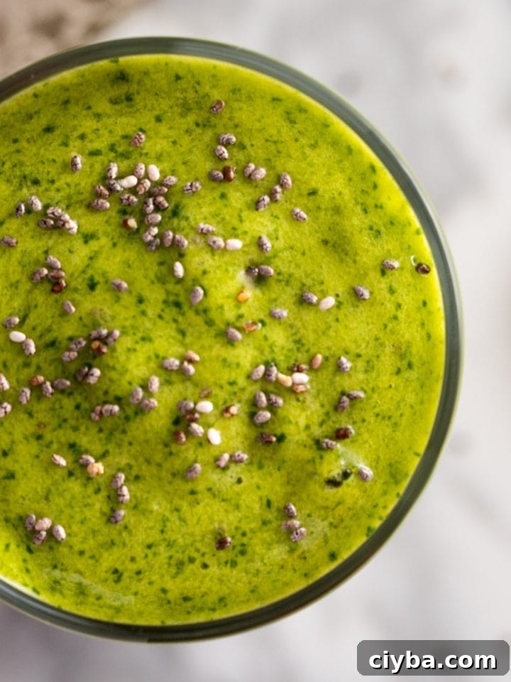 Up close, overhead view of a mango spinach smoothie, garnished with chia seeds.