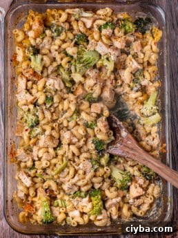 overhead view of chicken and broccoli pasta bake with a wooden spoon in it