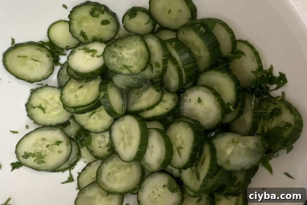 Cucumber salad final step adding cilantro vinegar salt and sugar.