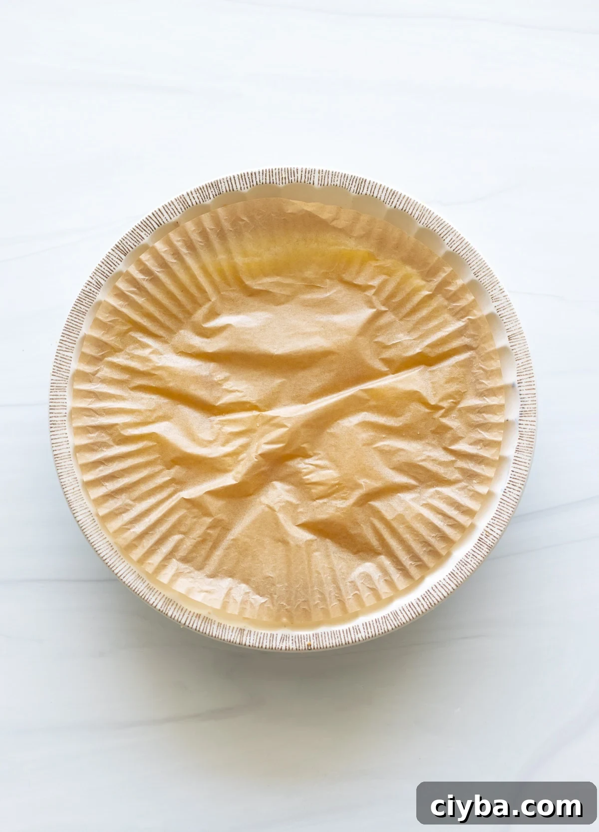 Parchment paper covering a lemon meringue pie filling so the film doesn't form.