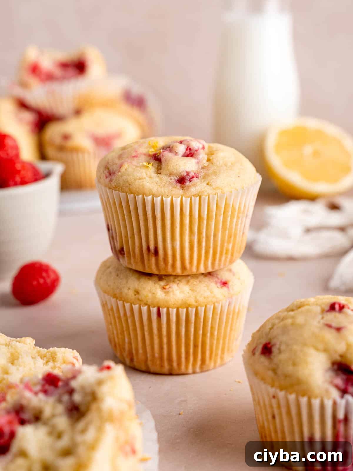 Lemon Raspberry Muffins with Zesty Lemon Glaze 2 Lemon raspberry muffins stacked on top of each other.