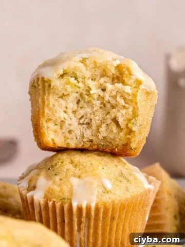 A stack of lemon zucchini muffins with lemon icing.
