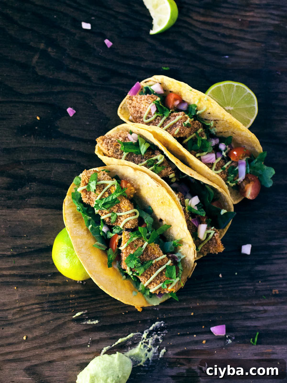 Three crispy squash tacos garnished with limes and cilantro