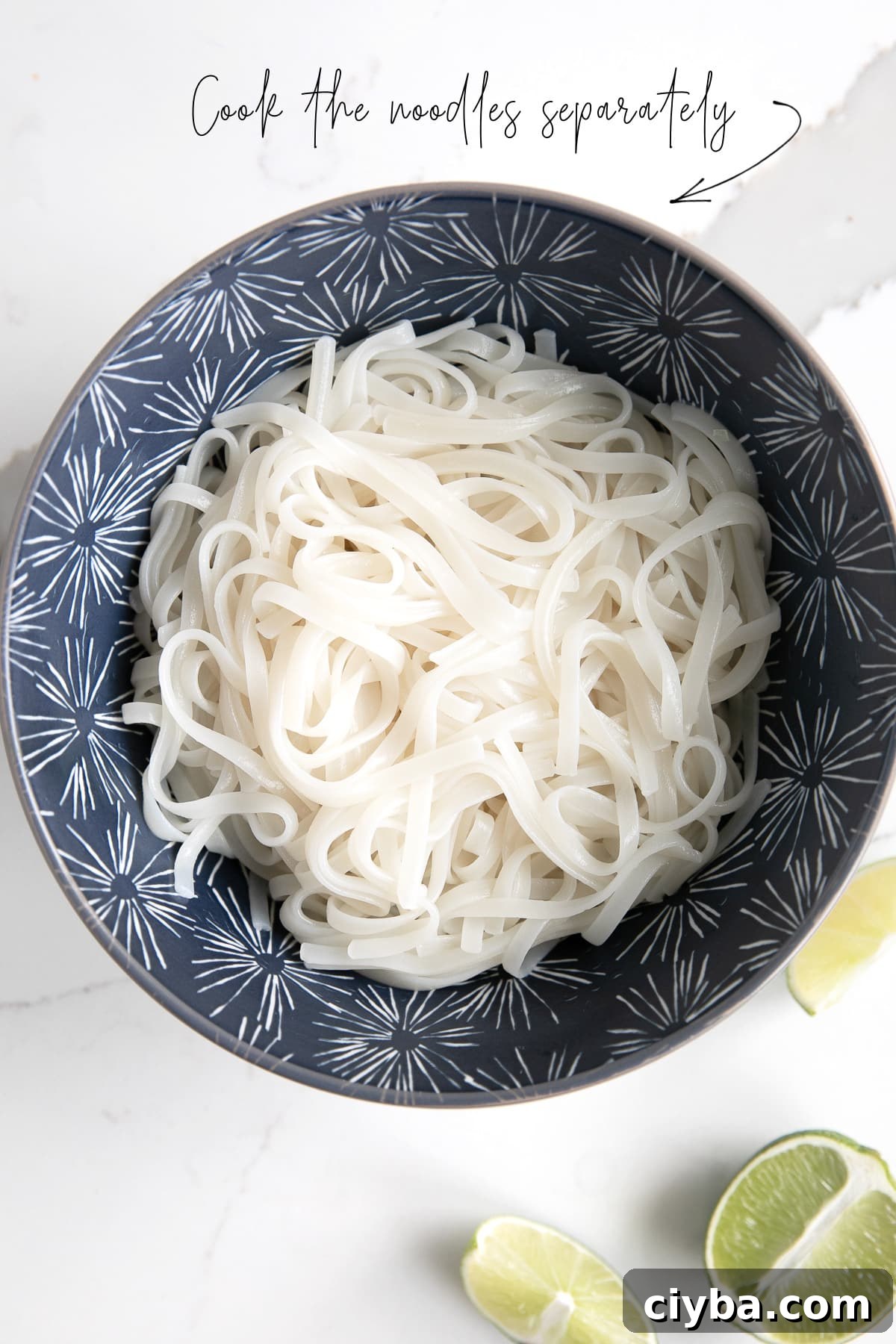 Thai Chicken Curry Noodle Soup: Authentic Recipe & Tips 5 A blue bowl full of cooked rice noodles, with text overlay stating, "cook the noodles separately" with an arrow pointing to noodles.