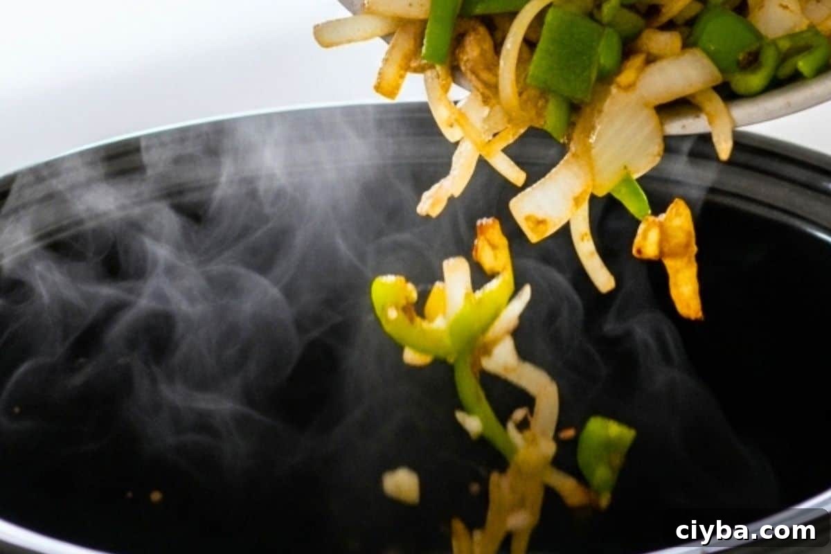 Cook the onions and green peppers in a pan and transfer the mixture to a 6-quart slow cooker bowl.