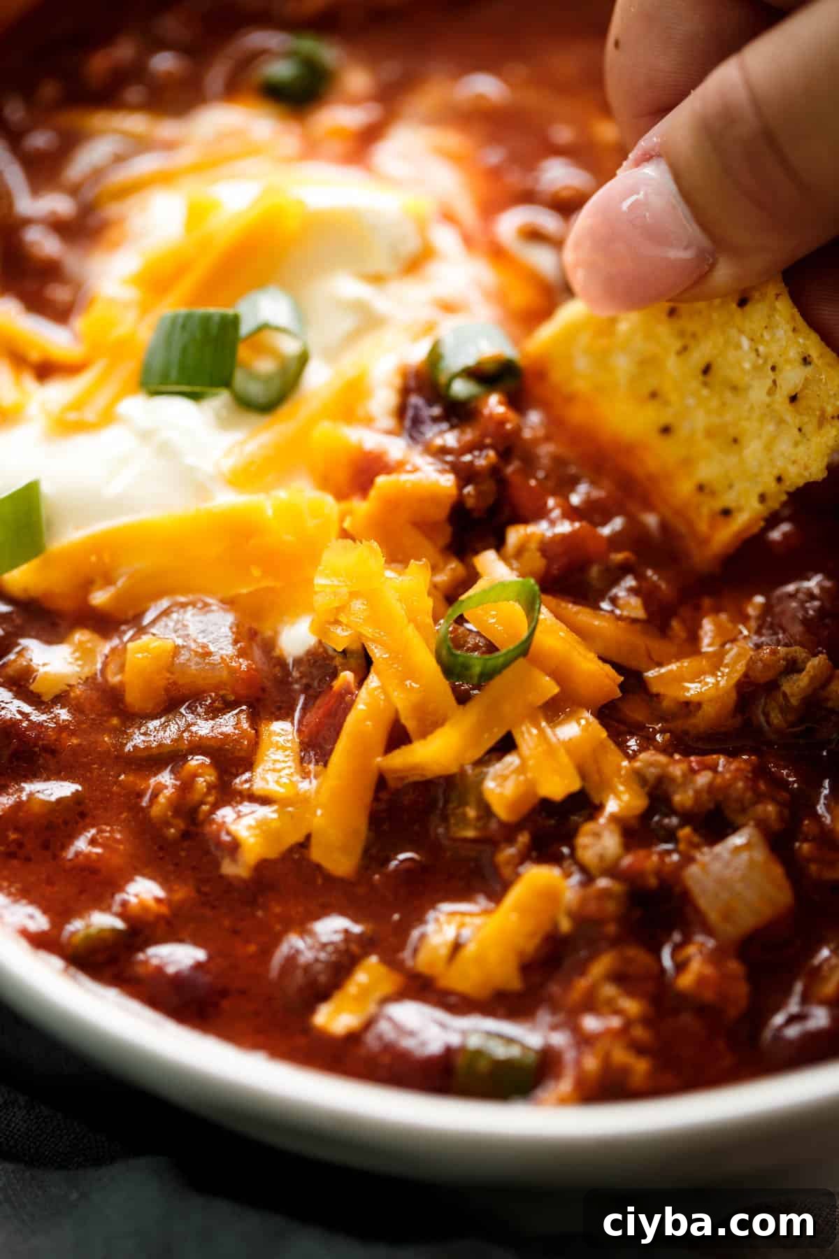 Yummy sloe cooker chili with nacho in white bowl