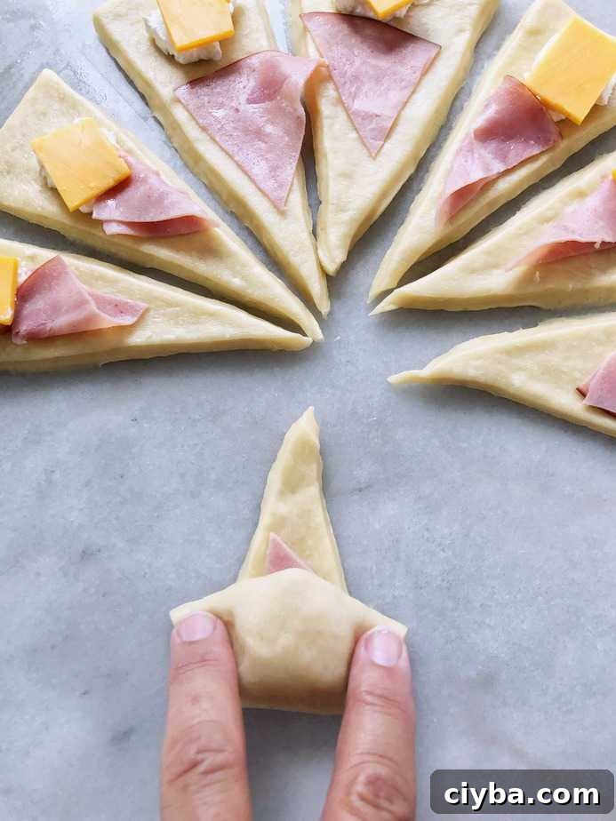 rolling up a ham and cheese crescent roll