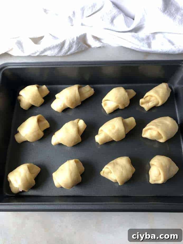 baking sheet with ham and cheese rolls ready to bake