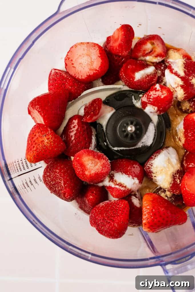 Frozen strawberries and milk in a blender.