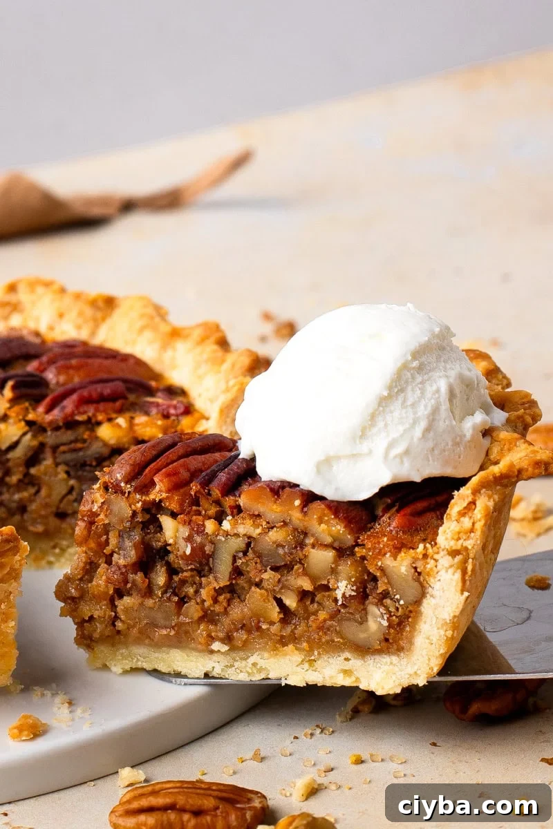 Gluten Free Pecan Pie with No Corn Syrup with a slice cut out on a spatula and icecream on top