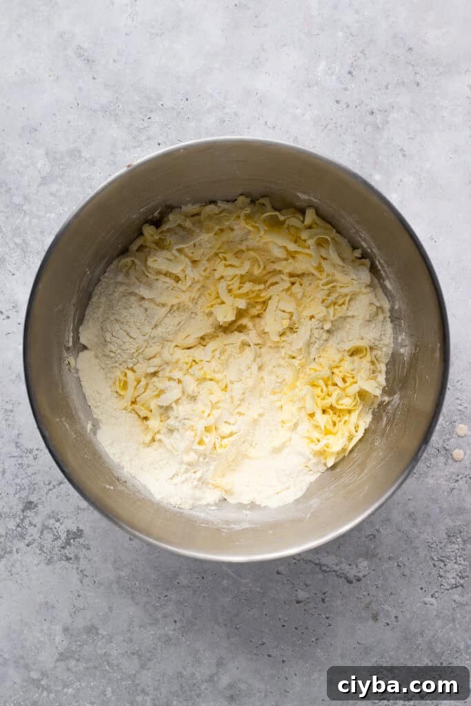Homemade Gluten Free Apple Pie with Flaky Crust being made with butter grated