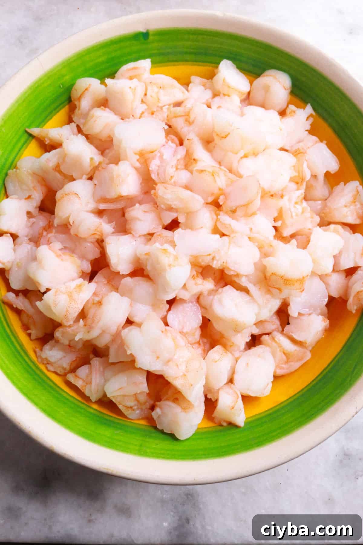Bowl with cooked shrimp cut into pieces