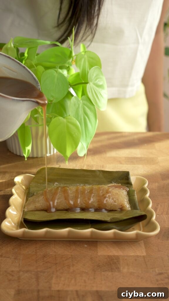 pouring latik syrup on a suman