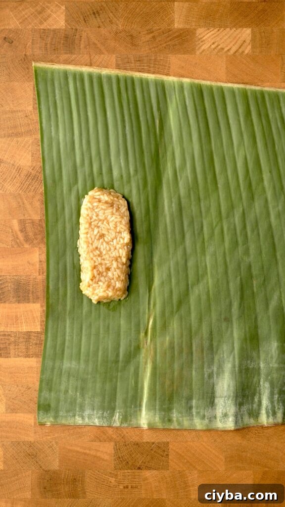 portion out some of the rice on a banana leaf