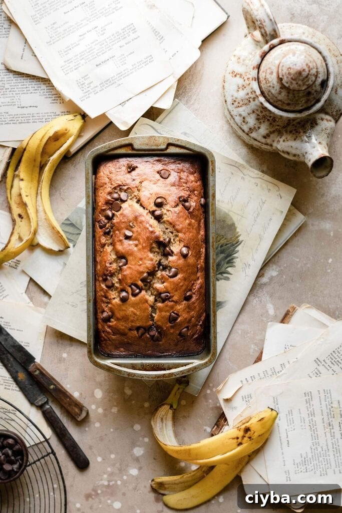 Loaf of banana bread on table with banana peels.