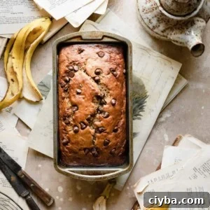 Loaf of banana bread on table with banana peels.