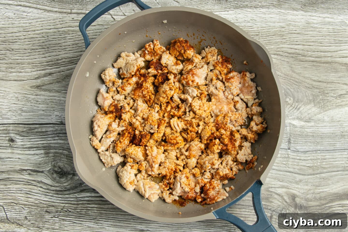 Chicken Nachos Recipe with Fresh Salsa and Avocado 5 This is a picture of a skillet with the ground chicken cooking.