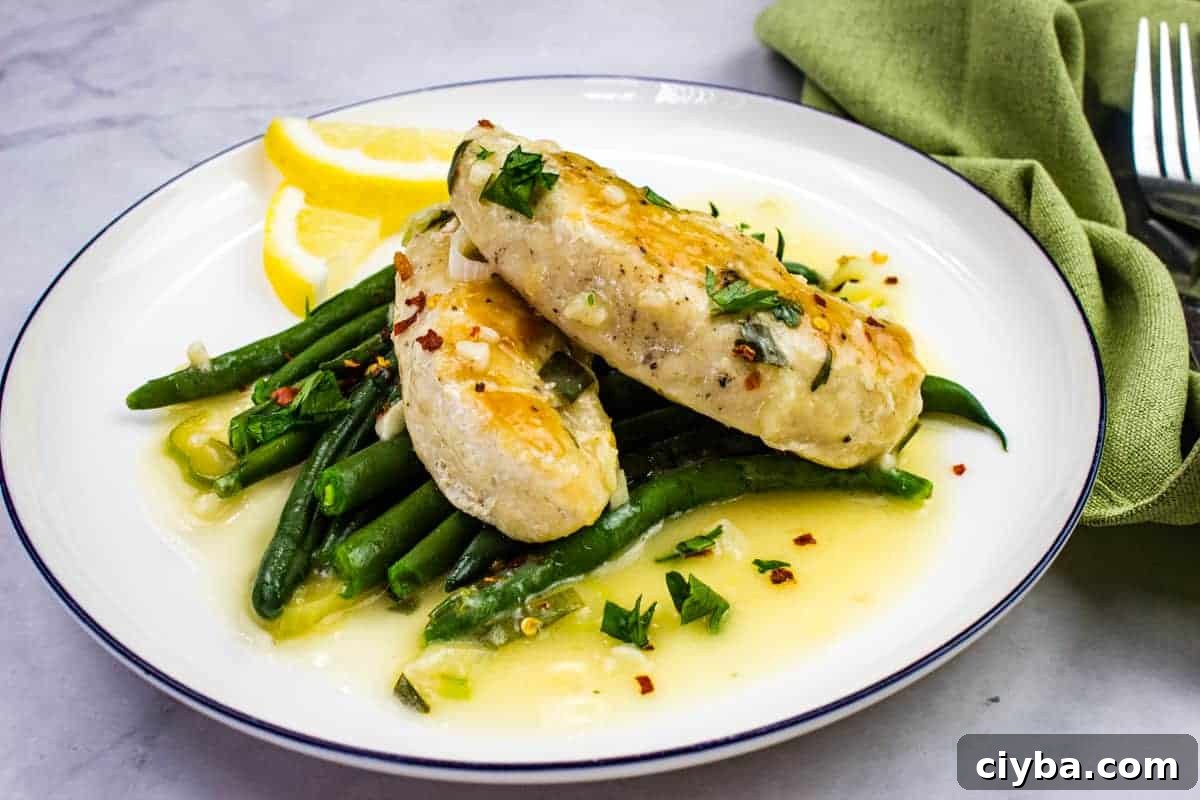 A white plate with Chicken Scampi and green beans resting in the center.