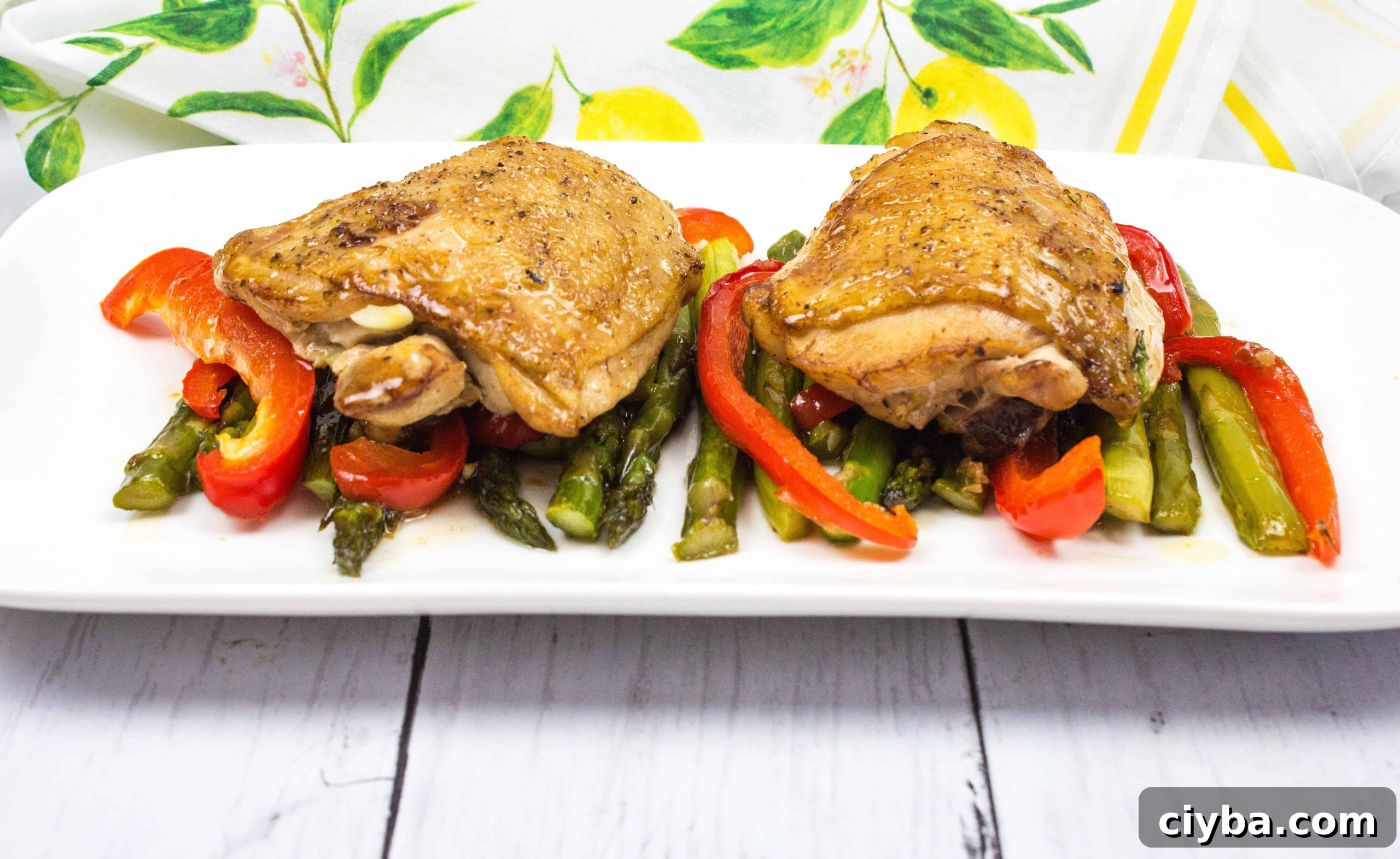 Garlic Chicken Skillet with peppers and asparagus on a white plate.