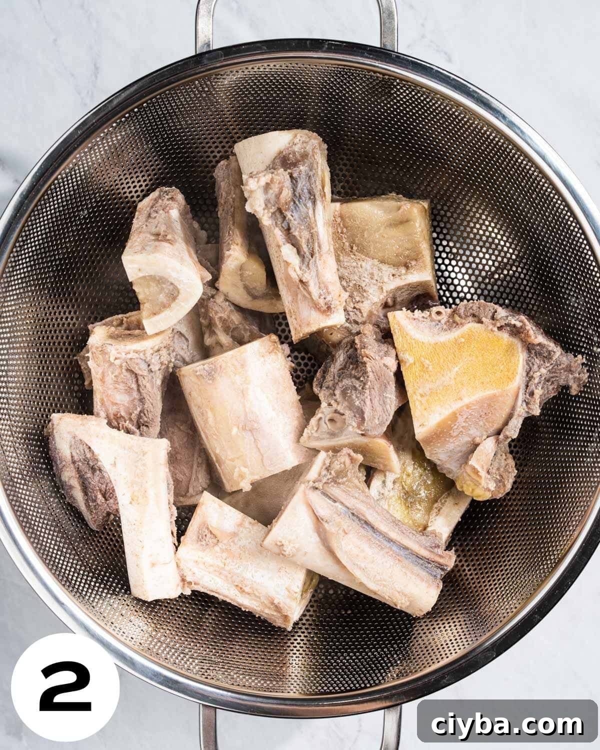Pre-boiled beef bones in colander.