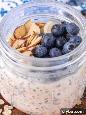 vanilla overnight oats in a 12 ounce Mason jar topped with blueberries and sliced almonds.
