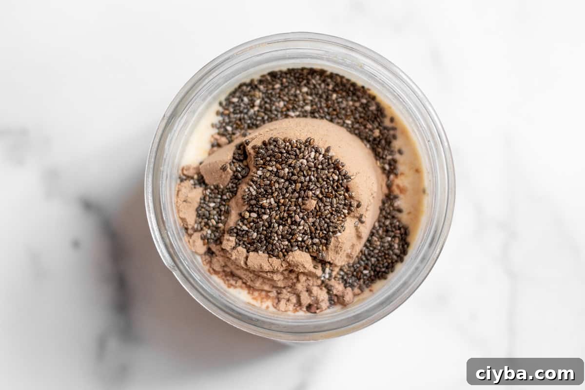 Top down view of ingredients for overnight oats in a jar before stirring.