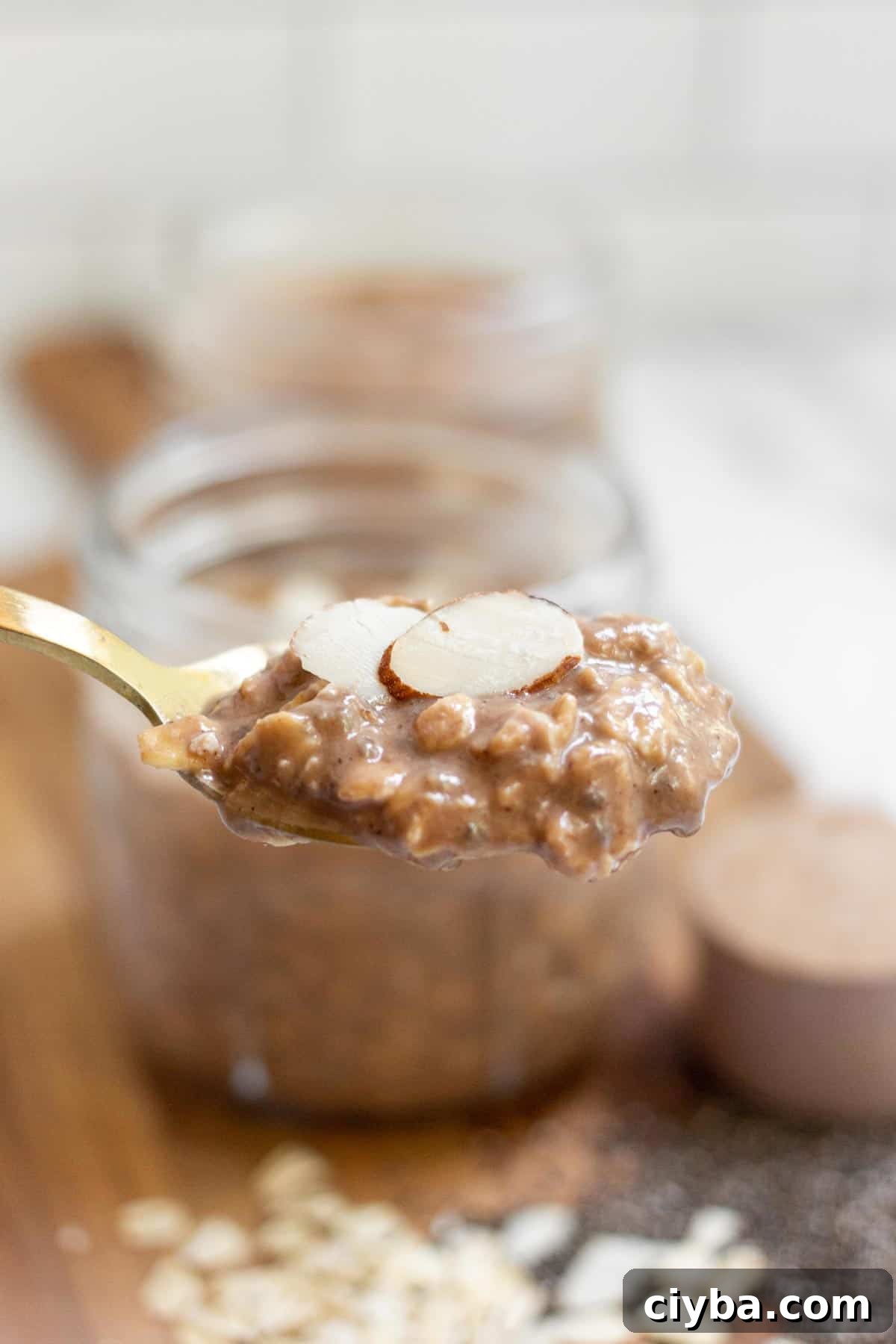 A spoonful of overnight oats with protein powder topped with almond slices.