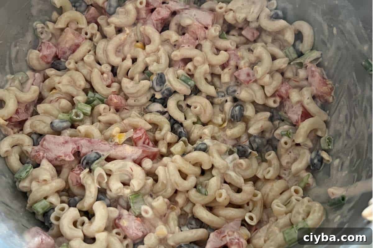 Salad ingredients all mixed together in a bowl for Mexican Macaroni Salad. 