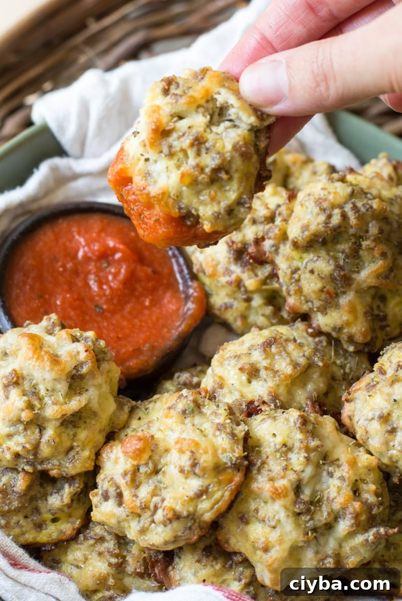 close up of a bowl of keto friendly pizza bites. once bite has just been dunked in marinara 