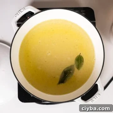 Whisking together cold water, olive oil, salt, bay leaves, and polenta.