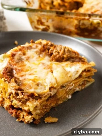 A square of lasagna on a plate.