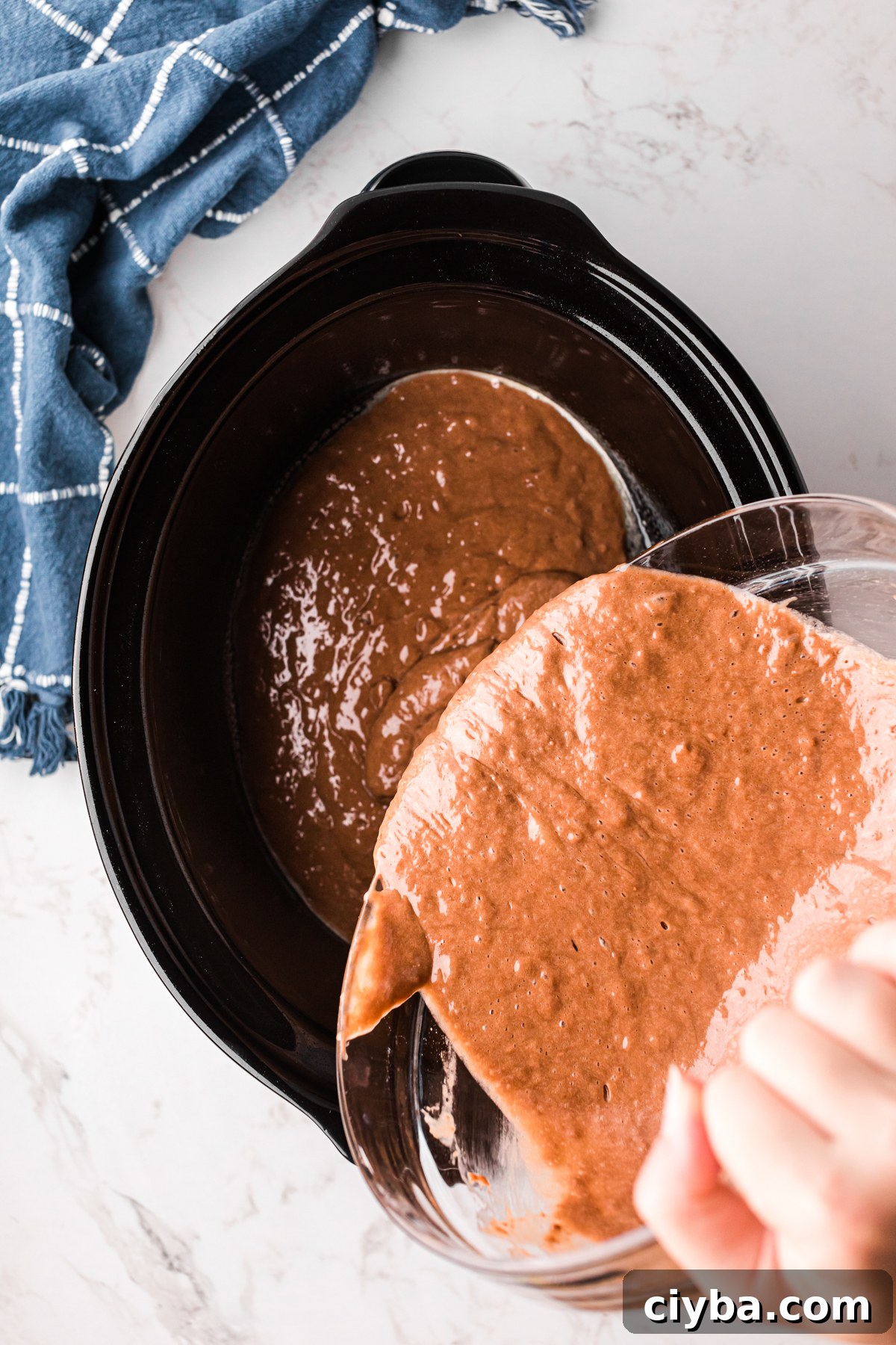 Slow Cooker German Chocolate Cake Recipe: Moist, Rich & Effortless 5 Adding chocolate cake batter to a crockpot.