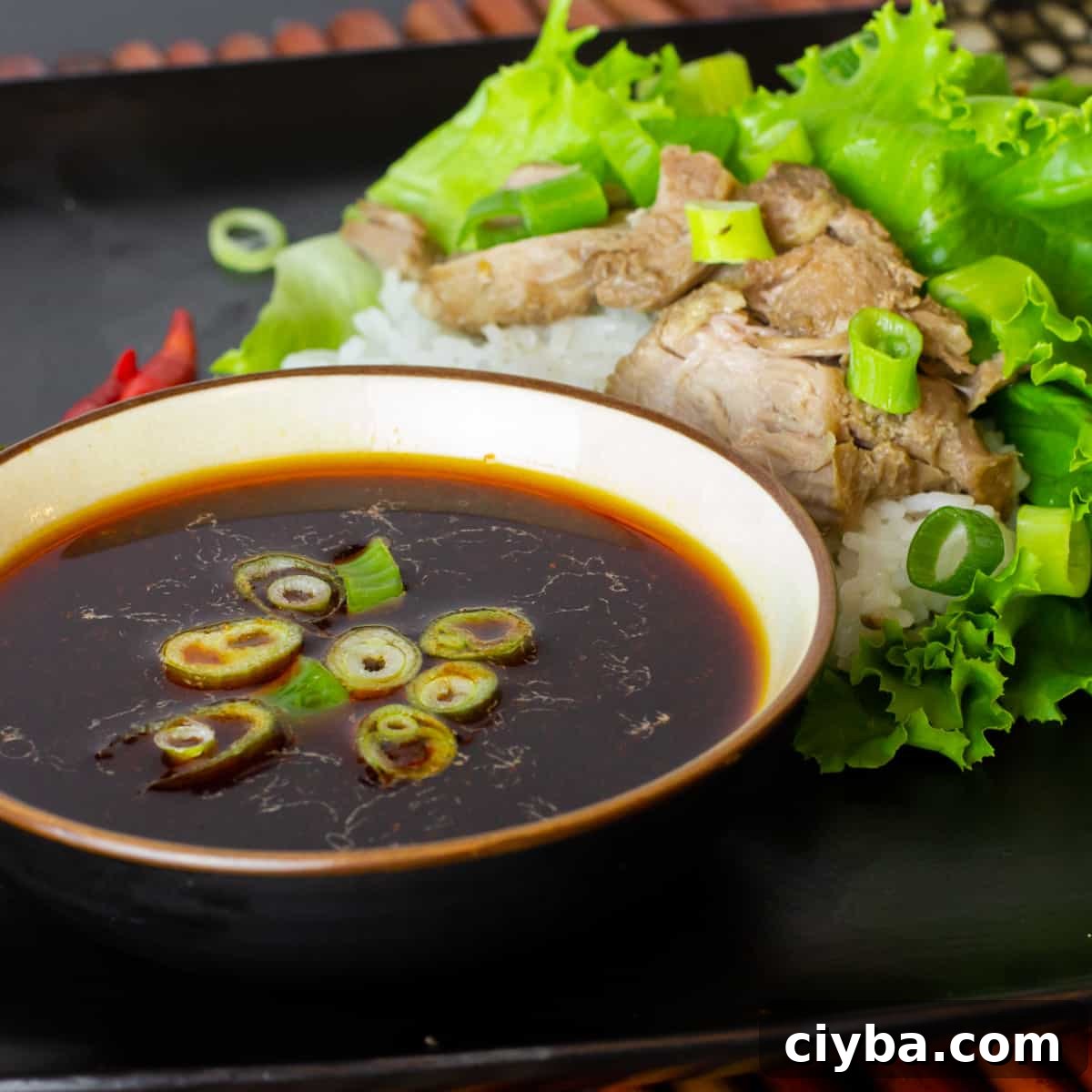 A plate with lettuce wraps and a bowl of sauce.
