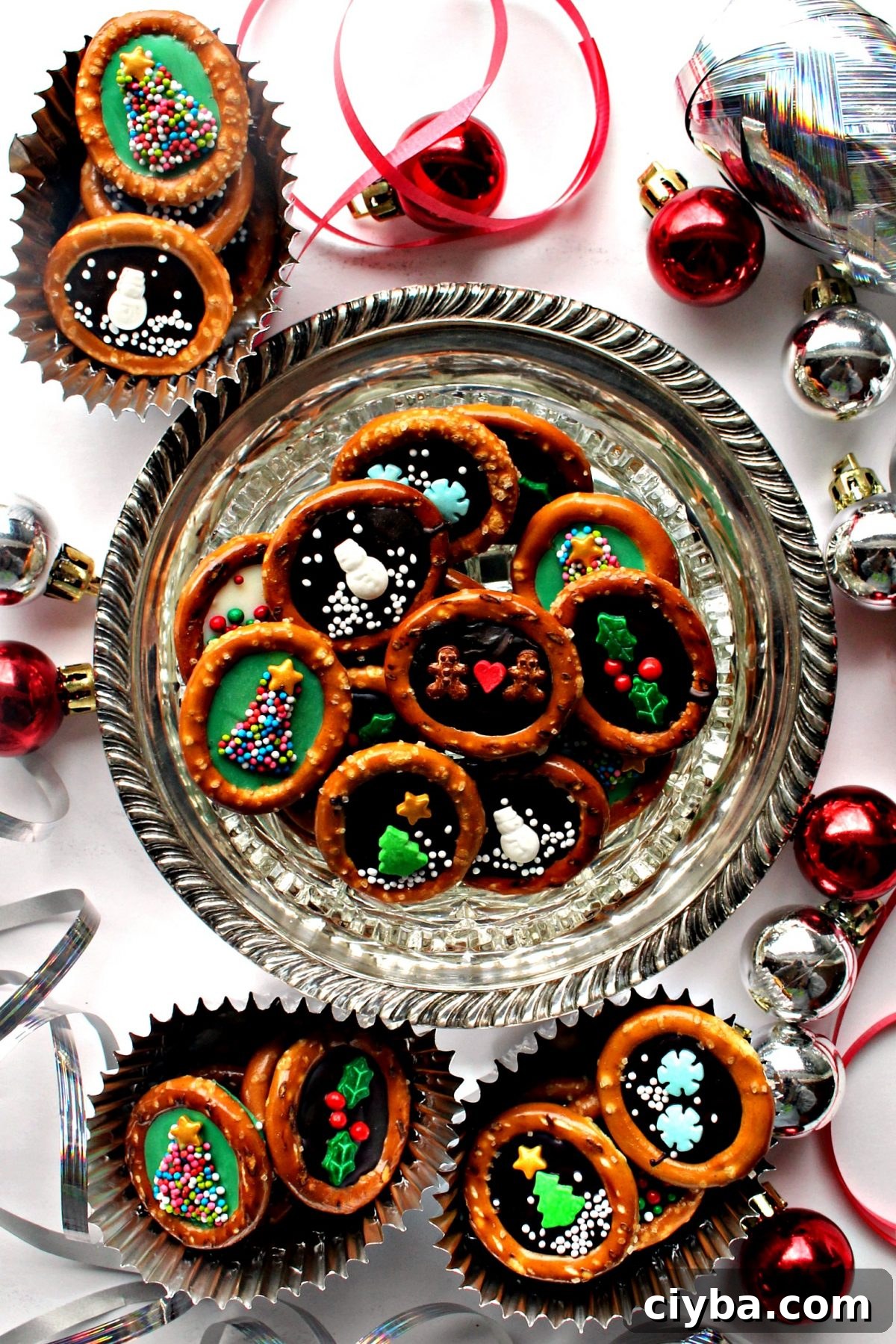 Pretzel rings with chocolate centers and sprinkle designs on a silver tray.