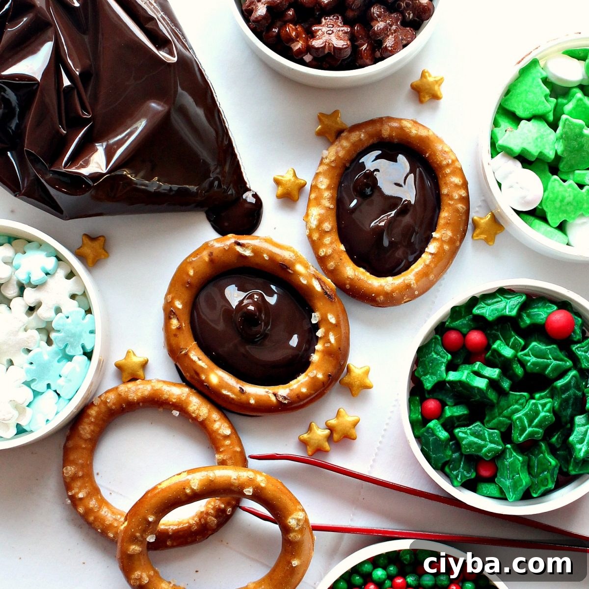 Pretzel rings with centers filled with melted chocolate surrounded by sprinkles for decorating.