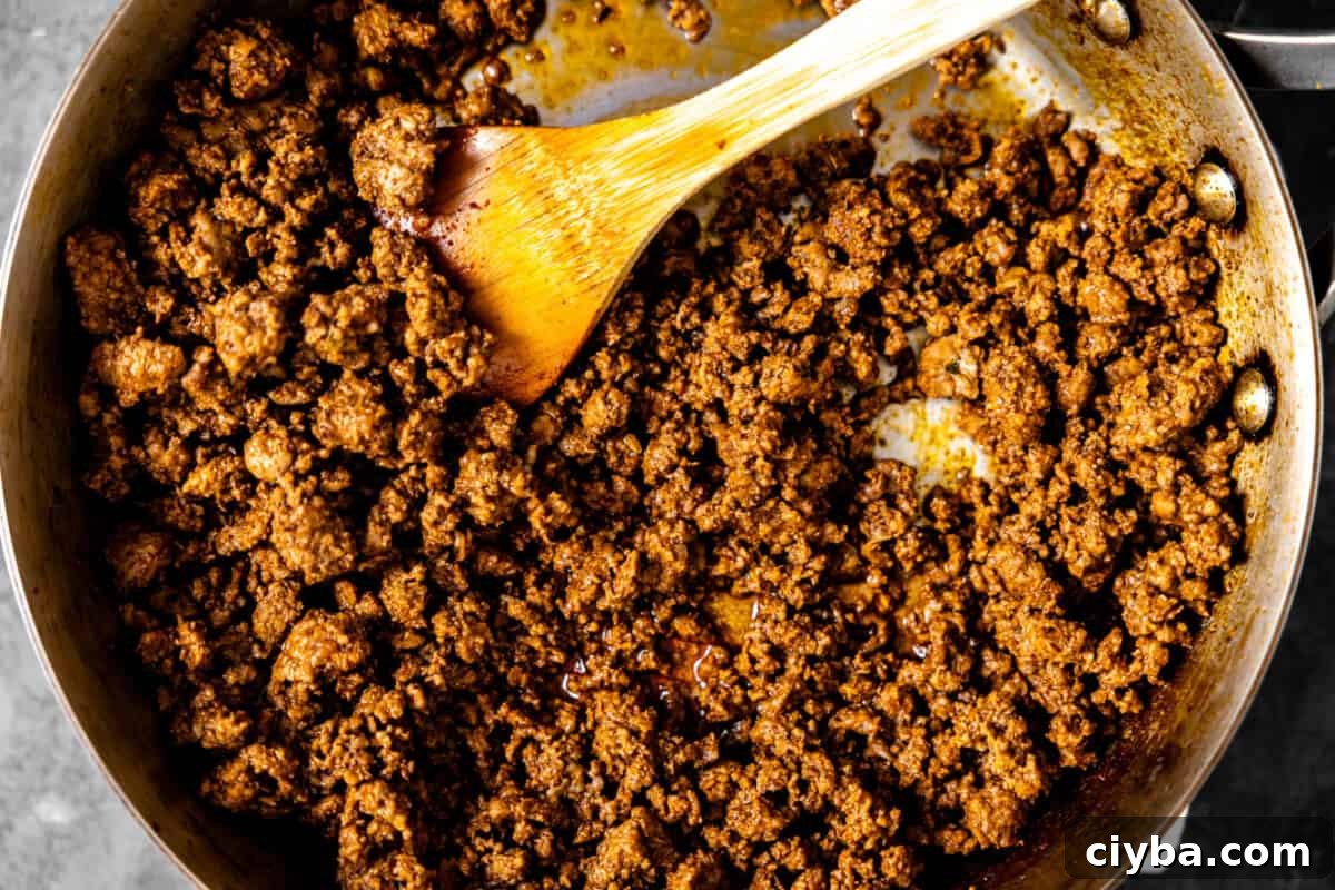 Taco meat being cooked in a skillet. 