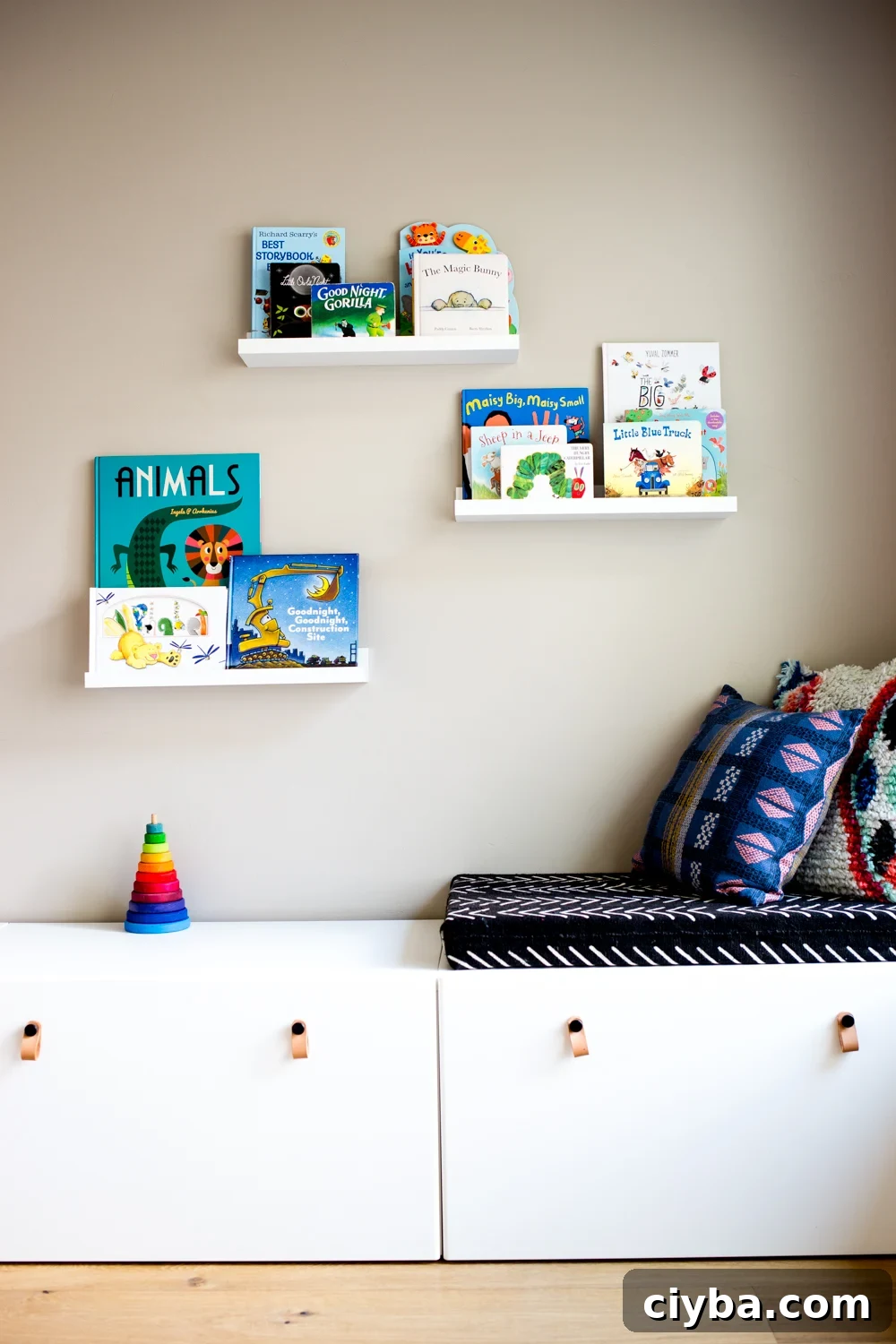 modern playroom with books on floating shelves and white storage drawers with bohemian and african mudcloth style cushions
