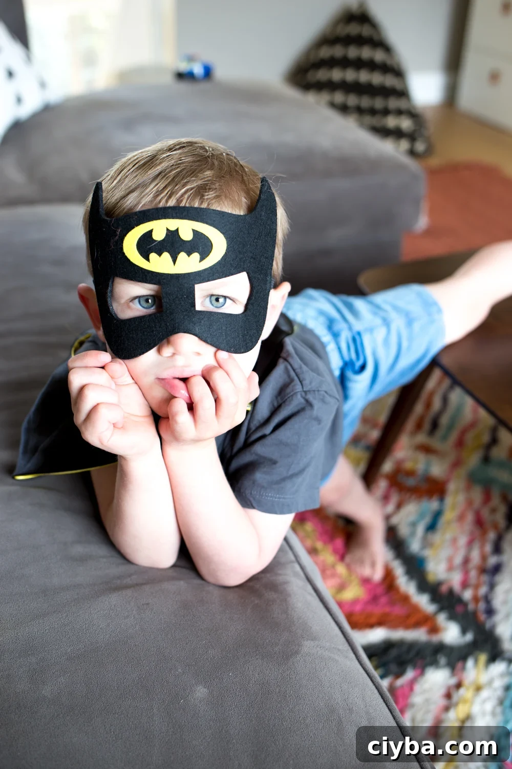 toddler boy with batman mask on in play room